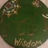 A green plate with an elephant and the word " wisdom ".