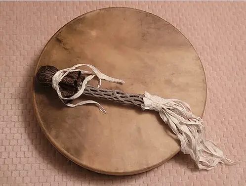 A wooden drum with a stick and string attached to it.