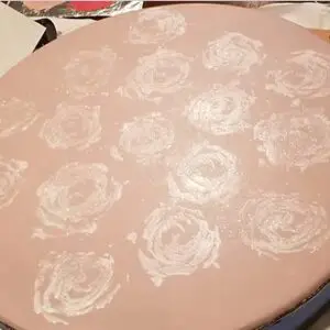 A pizza pan with some white roses on it