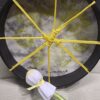 A yellow umbrella with a white flower on it.