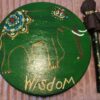 A wooden plate with the word " wisdom " written on it.