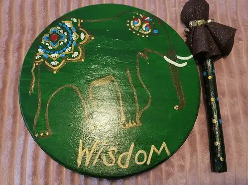A wooden plate with the word " wisdom " written on it.