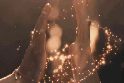 A person 's hands are lit up by the light.